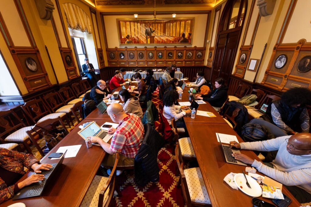 An overhead view of the Philodemic Room, filled with people sitting at wooden tables and conducting research on their laptops.